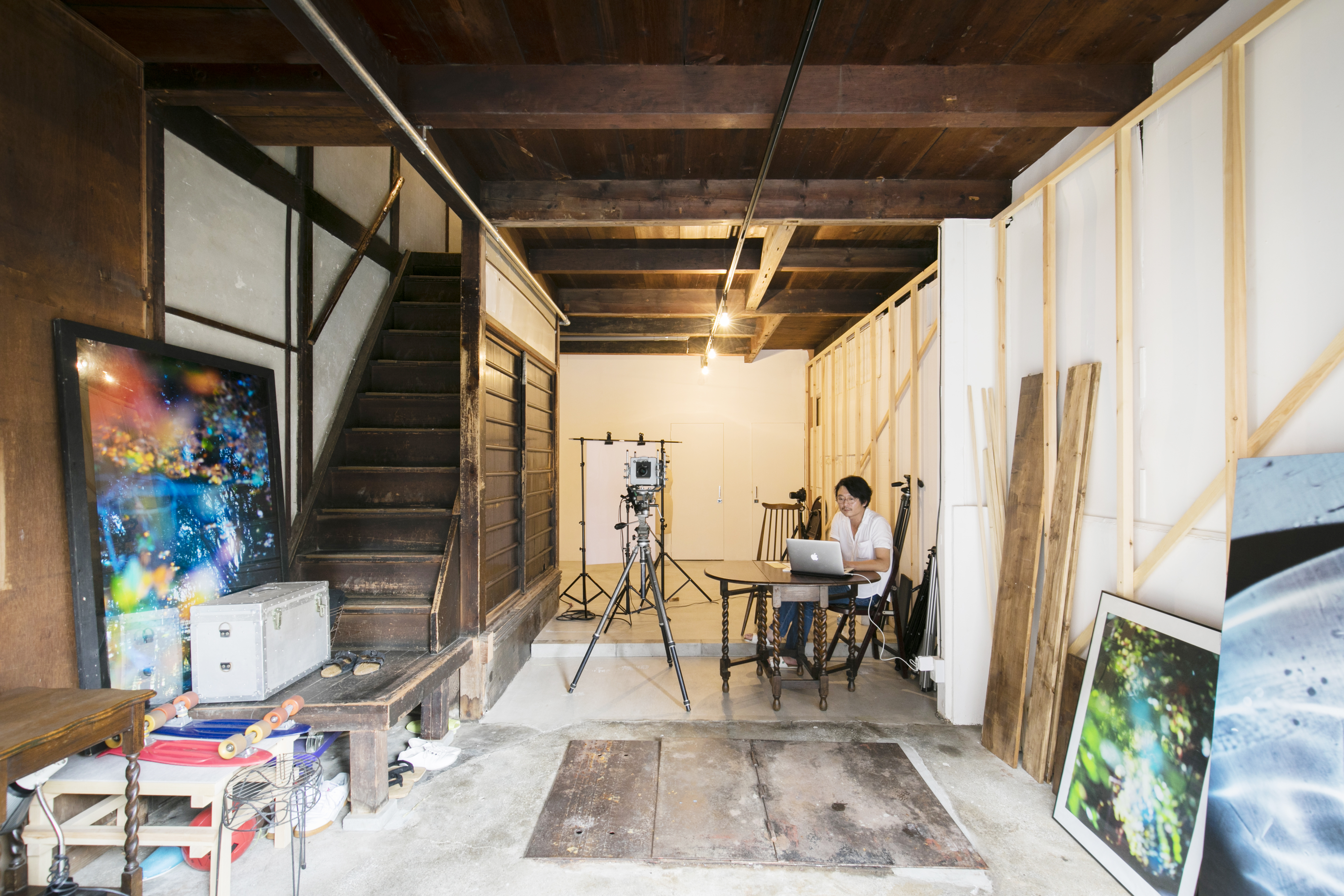 入居者第1号であるカメラマンの田中陽介さん。1階はスタジオ兼ガレージとして使用中。奥の合板壁はDIYで白く塗装したそう。